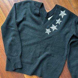 Black v-neck sweater with silver sequin stars